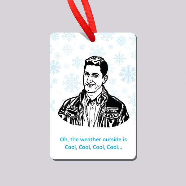 A Christmas ornament hanging from a red ribbon on a grey background. The ornament features a black-and-white illustrated portrait of Brooklyn Nine Nine's Jake Peralta, surrounded by light blue snowflakes and ending with the text 'Oh, the weather outside is Cool, Cool, Cool, Cool.'