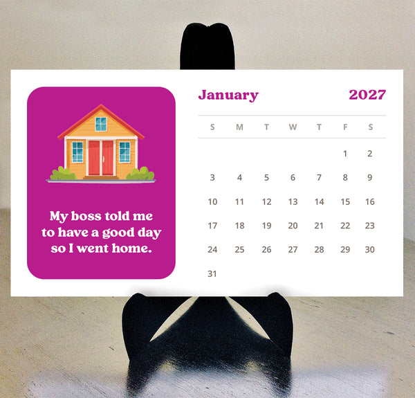 An adulting desk calendar for 2027 shown against a neutral background, featuring a bright pink block with a cartoon house and the text 'My boss told me to have a good day so I went home.' Calendar is sitting on a black easel.