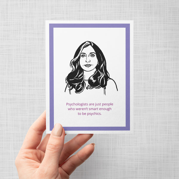 A hand holding a greeting card with an illustration of Brooklyn Nine Nine's Gina with text 'Psychologists are just people who weren't smart enough to be psychics'