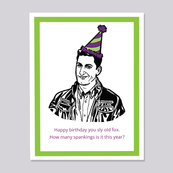 A greeting card featuring a black and white line art illustration of Brooklyn Nine Nine's Jake Peralta wearing a purple and green striped party hat, with a bright green border and pink text at the bottom that reads, 'Happy birthday you sly old fox. How many spankings is it this year?' The card is shown against a neutral gray background.