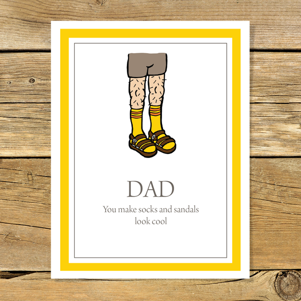 Greeting card with illustration of socks and sandals with text 'Dad you make socks and sandals look cool' on a wooden background