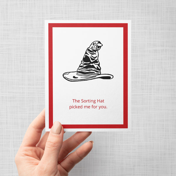 Hand holding a greeting card with illustration of the sorting hat from harry potter and text 'The sorting hat picked me for you'