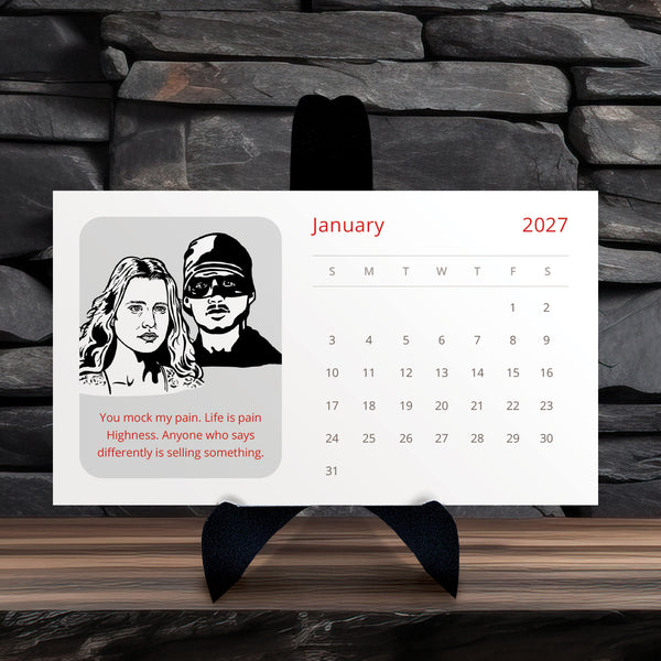 A Princess Bride 2027 calendar displayed on a black stand against a dark stone wall and wood surface. The calendar has a white background with red text, a black-and-white illustrated portrait of a couple, and a quote printed in red.