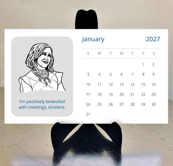 A Schitts Creek 2027 desk calendar displayed on a black stand against a beige wall. The calendar features a gray square with a black-and-white line drawing of Moira Rose and the text 'I'm positively bedeviled with meetings, etcetera.'