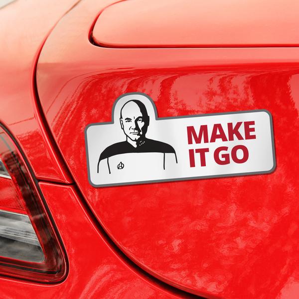A rectangular car decal applied to the side of a red car. The decal features a black-and-white portrait of Captain Picard with a Star Trek insignia, next to the red text 'MAKE IT GO'.