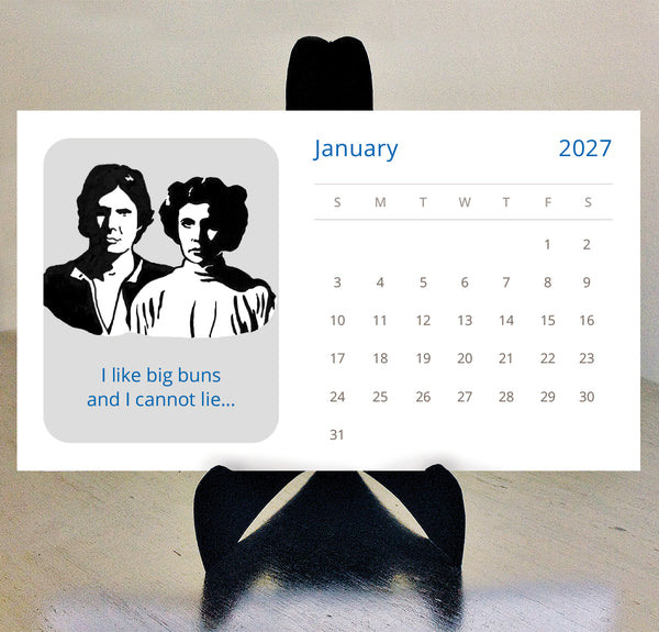 A 2027 Star Wars illustrated desk calendar on a black easel with a neutral background. Illustration of han solo and princess leia with text 'I like big buns and I cannot lie'