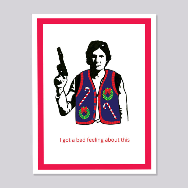 A greeting card featuring a stylized black-and-white illustration of Han Solo wearing a Christmas sweater vest with candy canes and wreaths, holding a gun. Below the illustration, red text reads, 'I got a bad feeling about this.
