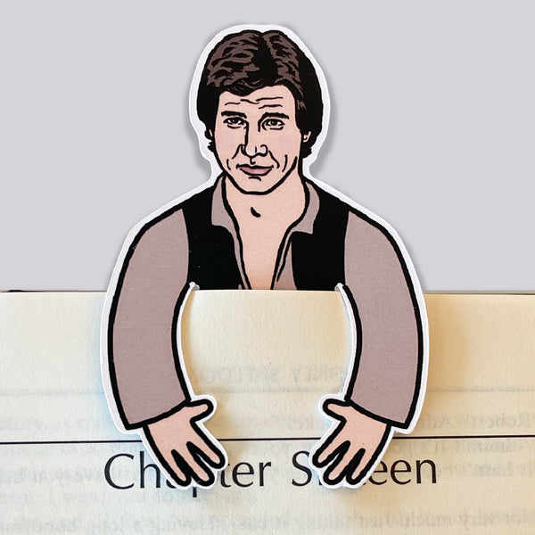Illustration of Star Wars Han Solo on a die cut bookmark with arms hooking over the front of a book page.