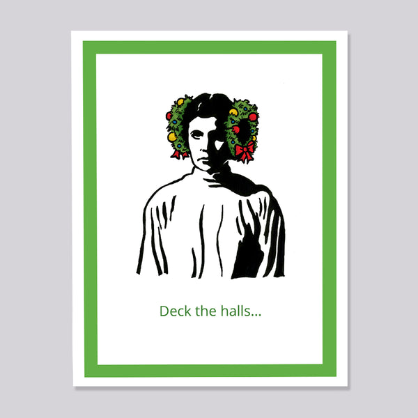 A greeting car featuring a stylized black-and-white portrait of Princess Leia with green holiday wreaths on the sides of her head, with the text 'Deck the halls. 