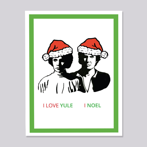 A greeting card featuring a minimalist black-and-white illustration of Princess Leia and Han Solo wearing red Santa hats, with the text 'I LOVE YULE | I NOEL' at the bottom. The card has a white border and a green inner border, shown against a light gray background.