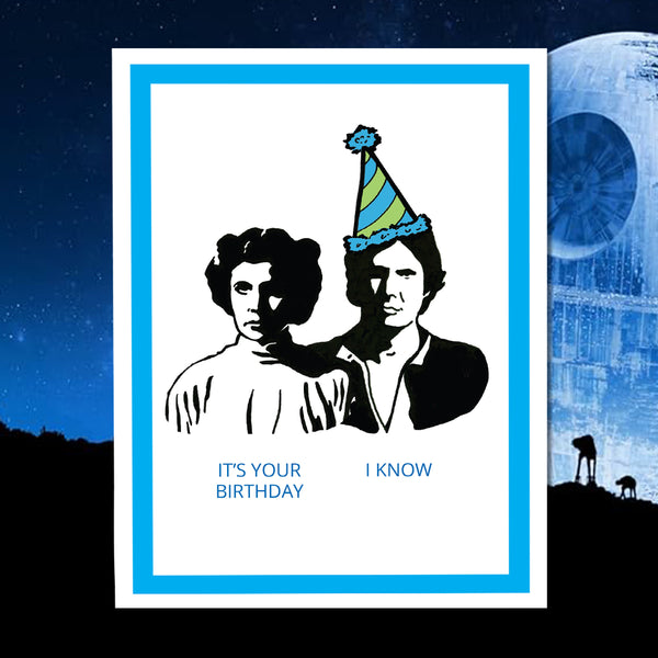 Greeting card with black and white illustrations of Princess Leia and Han Solo wearing party hats, text 'It's your birthday' and 'I know', on a space background.