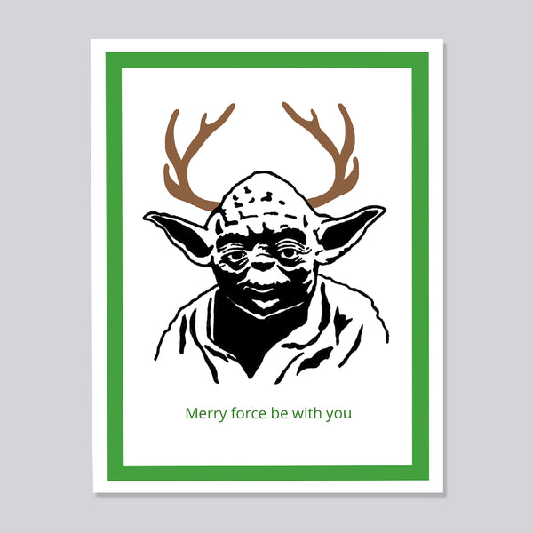 A greeting card featuring a stylized black-and-white portrait of Yoda with brown antlers and green text reading 'Merry force be with you' at the bottom, framed by a green border on a white print background against a light gray backdrop.