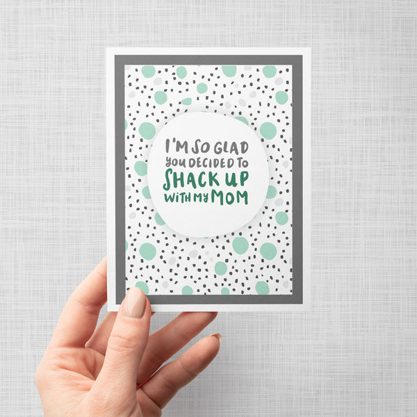 Greeting card with hand lettered text 'I'm so glad you decided to shack up with my mom' on a polka dot background.