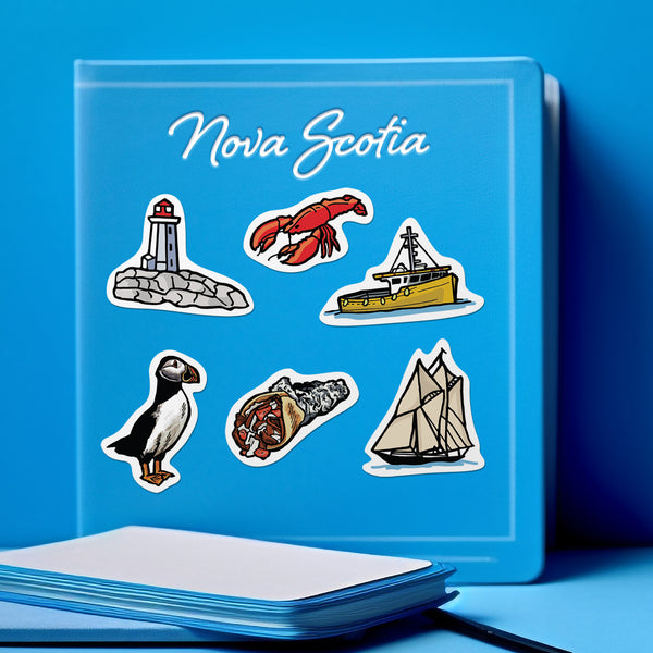 Blue notebook with a collection of die cut illustrated stickers featuring iconic symbols of Nova Scotia such as a lobster, a lighthouse, a fishing boat, a puffin, a donair and the bluenose.on a blue background
