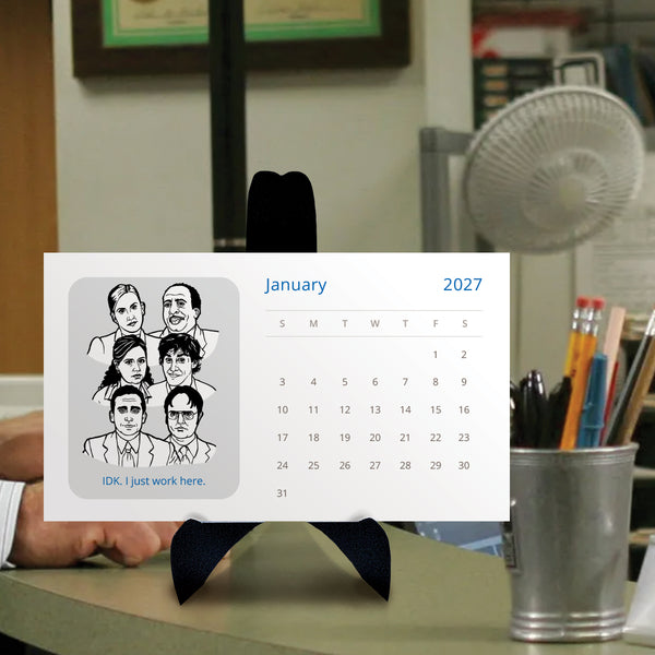 A 2027 desk calendar card featuring black-and-white illustrated portraits of characters from The Office tv show and the text 'IDK. I just work here.