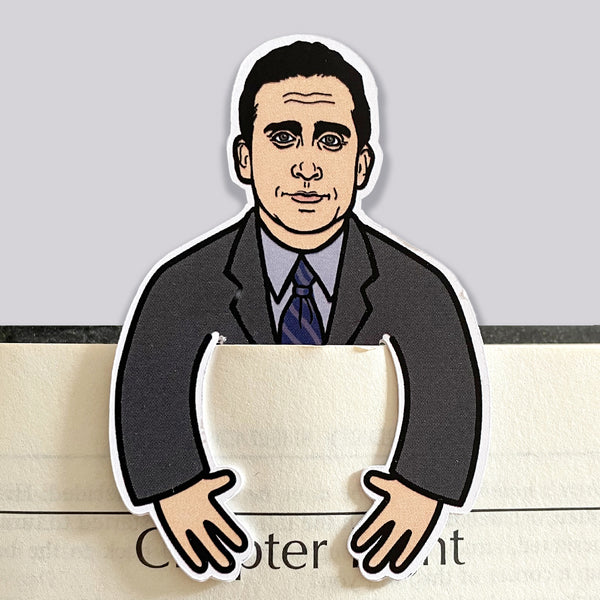 Michael scott character from the office as a die cut bookmark. His arms clip over the front of a book page.
