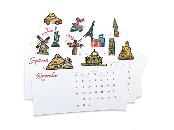 A set of travel-themed calendar cards stacked on a white background, featuring small illustrated landmarks such as the statue of liberty, the taj mahal, pyramds, big ben and the statue of liberty along the top.