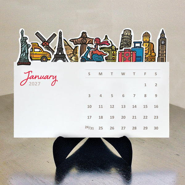 A 2027 desk calendar page featuring colorful travel-themed illustrations such as the statue of liberty, the taj mahal, pyramds, big ben and the statue of liberty along the top, displayed on a black stand against a neutral beige background.